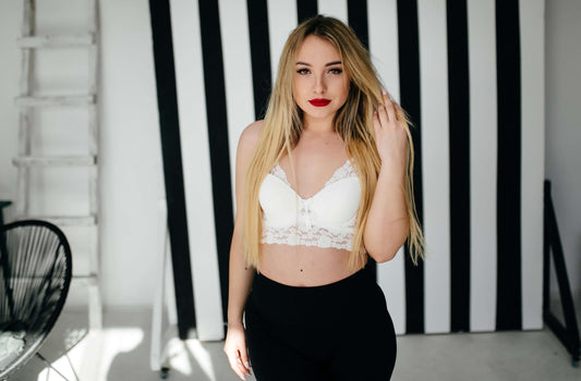 Model wearing a white soft bra with lace details, styled against a striped background.